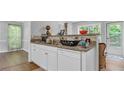 Bright kitchen featuring granite countertops, white cabinets, and stainless steel sink at 190 Crestworth Ct, Powder Springs, GA 30127