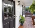Close-up showcasing the inviting covered porch, stylish black door, and decorative potted plants at 306 Birch St, Canton, GA 30114