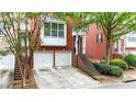 Attractive brick townhome with a two-car garage, and inviting entrance framed by mature trees at 5439 Alanis Se Pl # 17, Mableton, GA 30126
