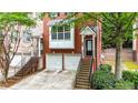 Charming brick townhome showcasing a two-car garage, and inviting entrance surrounded by greenery at 5439 Alanis Se Pl # 17, Mableton, GA 30126
