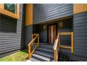 A modern front entrance featuring a wood door, gray siding, and natural wood trim accents at 2155 Venetian Sw Dr, Atlanta, GA 30311