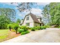 A charming two-story home with mature landscaping and a long driveway leading to a covered parking area at 529 Arnold Rd, Lawrenceville, GA 30044