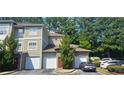 Townhouse exterior with attached garages, a red front door, and mature trees surrounding the property at 2700 Pine Tree Ne Rd # 3009, Atlanta, GA 30324