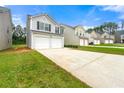 View of homes showing attached garages, driveways, and lawns in a quiet suburban neighborhood at 7495 Garnet Dr, Jonesboro, GA 30236