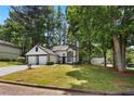 Charming two-story home with a two-car garage, manicured lawn, and mature trees at 5383 Biffle Way, Stone Mountain, GA 30088
