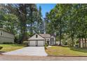 Charming two-story home with a two-car garage, manicured lawn, and mature trees on a sunny day at 5383 Biffle Way, Stone Mountain, GA 30088