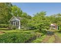 Quaint home featuring a screened front porch surrounded by lush greenery and a spacious lawn at 850 Fourth St, Stone Mountain, GA 30083