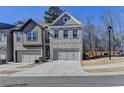 Attractive townhome with a gray brick exterior, two-car garage, and well-maintained landscaping at 2132 Arnage Dr, Lithonia, GA 30058