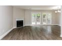 Spacious living room featuring hardwood floors, a fireplace, and access to the backyard through French doors at 3474 Kingswood Run, Decatur, GA 30034