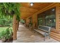 Spacious covered porch with hanging ferns, bench seating, and natural wood flooring; great for relaxation at 6605 Old White Mill Rd, Fairburn, GA 30213