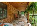 Inviting front porch with a swing and rocking chairs, offering a relaxing outdoor space with log siding at 6605 Old White Mill Rd, Fairburn, GA 30213