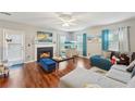 Cozy living room with a fireplace, hardwood floors, a ceiling fan, and bright natural light at 701 Fir Chase, Fairburn, GA 30213