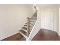 Bright entryway with hardwood floors, stairs with metal railings, and a white front door at 3075 Westpoint Cir, Snellville, GA 30078