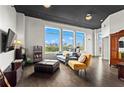 Bright living room with hardwood floors, large windows boasting city views, and stylish contemporary furniture at 3820 Roswell Ne Rd # 1001, Atlanta, GA 30342