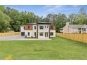 Attractive two-story home with a combination of white brick and wood, set on a large, green lot at 1349 Oak Road, Lilburn, GA 30047