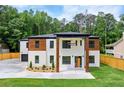 Beautifully designed two-story home with a mix of white brick and wood, complemented by lush green lawn at 1349 Oak Road, Lilburn, GA 30047