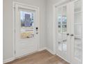 Front door and french doors into flex space, showcasing the wood-look flooring and neutral walls at 1462 Stephens View Dr, Loganville, GA 30052