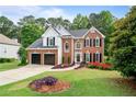 Charming brick two-story home with a two-car garage and a beautifully landscaped front yard at 523 Huntgate Rd, Woodstock, GA 30189