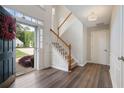 Bright foyer featuring hardwood floors, a staircase, and natural light from the front door at 523 Huntgate Rd, Woodstock, GA 30189