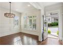 Elegant entryway featuring hardwood floors, white trim, an ornate chandelier, and plantation shutters at 5981 Brundage Ln, Norcross, GA 30071