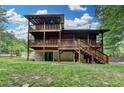 Exterior log home showcasing a multi-level deck and walkout basement on a lush green lawn at 2864 Winder Hwy, Dacula, GA 30019