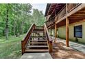 Exterior staircase leading to a multi-level deck of a log home surrounded by trees at 2864 Winder Hwy, Dacula, GA 30019