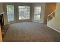 Spacious living room featuring multiple windows, neutral paint, and a fireplace at 1165 Oaks Pl, Stone Mountain, GA 30083