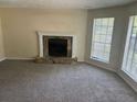 Inviting living room featuring a stone fireplace, neutral paint, and large windows offering natural light at 1165 Oaks Pl, Stone Mountain, GA 30083