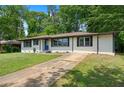 Single-story home with brick and siding, well-maintained lawn and a concrete driveway at 1824 Atherton Dr, Decatur, GA 30035