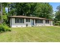 Charming single-story home with well-maintained lawn, painted white brick, contrasting trim and a blue front door at 1824 Atherton Dr, Decatur, GA 30035