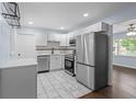 Modern kitchen with stainless steel appliances, white cabinets, stone countertops, and elegant marble tile flooring at 1824 Atherton Dr, Decatur, GA 30035