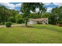 Beautiful single-story home with lush green lawn, mature trees, and a two-car garage at 3217 New Rutledge Nw Rd, Kennesaw, GA 30152