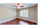 Cozy bedroom featuring hardwood floors, a ceiling fan, and plantation shutters for ample natural light at 2058 Bonneville Ln, Powder Springs, GA 30127