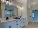 Bright bathroom features double sinks, vanity with drawers, and a large mirror over a stone countertop at 220 Nicklaus Cir, Social Circle, GA 30025