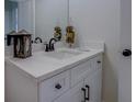 Modern bathroom vanity with white cabinets, countertop, and decorative accents at 220 Nicklaus Cir, Social Circle, GA 30025