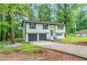 View of the exterior of the home, showing landscaping and two car garage at 5857 Earlwane Dr, Lithonia, GA 30058