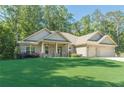 Beautiful brick home with a well-kept lawn and a wide driveway leading to a two-car garage at 150 Whitworth Dr, Locust Grove, GA 30248