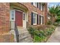 Inviting front entrance with a red door framed by sidelights and concrete steps with metal railings at 27 Jefferson Hill Ne Pl, Atlanta, GA 30342