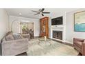 Cozy living room featuring a fireplace, ceiling fan, and comfortable seating with access to the dining room at 27 Jefferson Hill Ne Pl, Atlanta, GA 30342