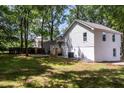 A spacious backyard and home's rear exterior are framed by mature trees at 8420 Sheridan Dr, Jonesboro, GA 30236