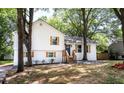 Attractive two-story house with wooden shutters, newly painted white exterior, landscaped yard, and tree shaded front at 8420 Sheridan Dr, Jonesboro, GA 30236
