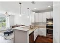 Bright kitchen featuring white cabinets, stainless appliances, and a peninsula with granite countertops at 10 Perimeter Summit Ne Blvd # 4243, Brookhaven, GA 30319