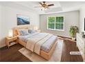 Staged bedroom featuring a ceiling fan, large window and hardwood floors at 145 Shadowbrook Trce, Covington, GA 30016