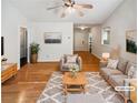 Bright living room features hardwood floors, neutral paint, ceiling fan, and comfortable furniture arrangement at 145 Shadowbrook Trce, Covington, GA 30016