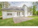 Backyard featuring a white exterior with a chimney, a concrete patio, and a well-maintained lawn at 2180 Briarwood Ct, Villa Rica, GA 30180