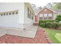 Close up of a house's entrance with a bright red door and a well-kept garden at 2180 Briarwood Ct, Villa Rica, GA 30180