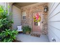 Inviting front porch with a cozy seating area and a decorative potted fern at 2534 Norwood Park Xing, Atlanta, GA 30340