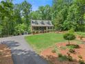 Beautiful home nestled in a lush, wooded setting with a long driveway and well-kept landscaping at 2170 Jonquil Ct, Canton, GA 30115
