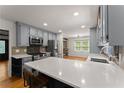 Stylish kitchen with updated appliances, a breakfast bar, and views into the living area at 2170 Jonquil Ct, Canton, GA 30115