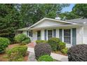 A well-maintained ranch-style house with white siding, green shutters, and a meticulously landscaped front yard at 2384 Shadowood Sw Dr, Conyers, GA 30094